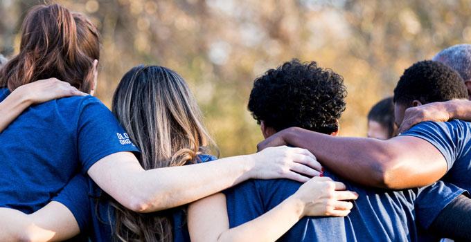 students in huddle shown from backs